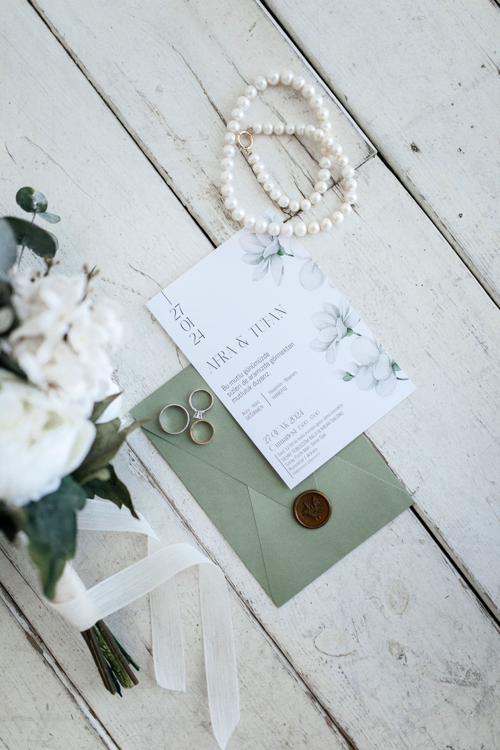 Wedding rings beside an invitation